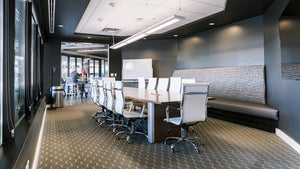 Press Coffee Biltmore's modern, sleek conference room featuring a large table and many chairs.