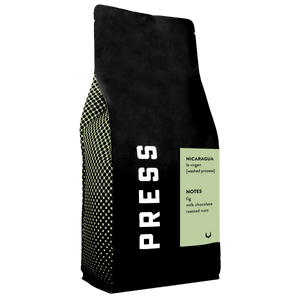 Black coffee bag with 'PRESS' branding and coffee flavor notes on a white background