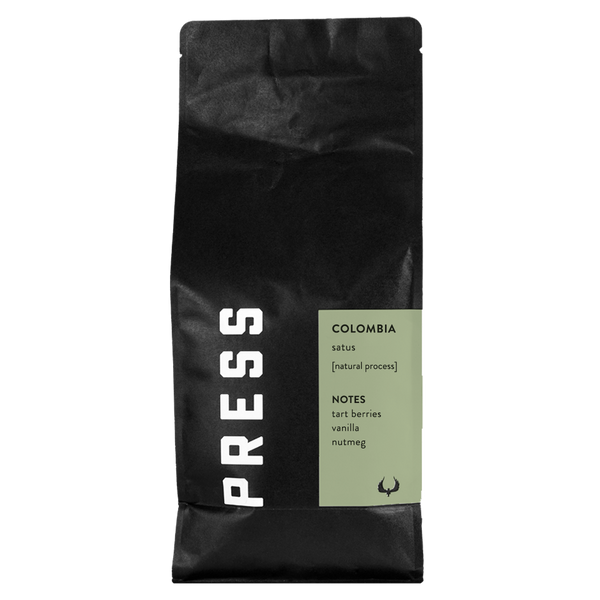 Black coffee bag with 'PRESS' branding and Colombia coffee details on a white background