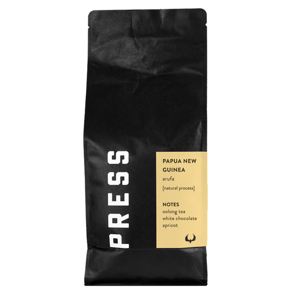 Black coffee bag with a yellow label featuring 'PRESS' branding and coffee information on a white background.