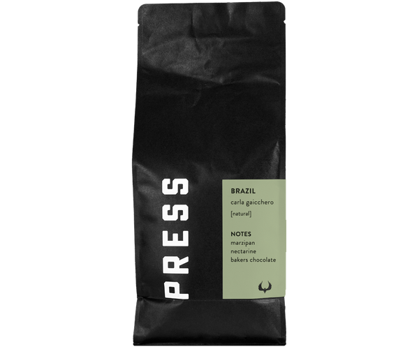 Forward facing view of Brazil carla gaicchero natural process coffee bag. Features notes of marzipan, nectarine, and bakers chocolate. 